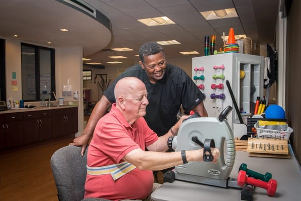 Resident engaging in therapy with staff assistance