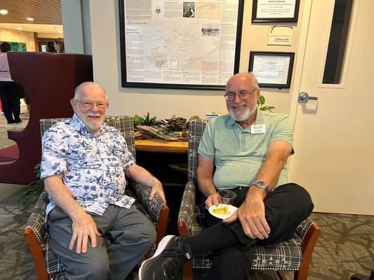 Two residents enjoying refreshments in a common area