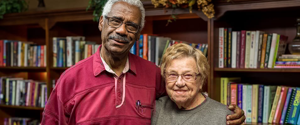 Two residents smiling in a cozy library setting