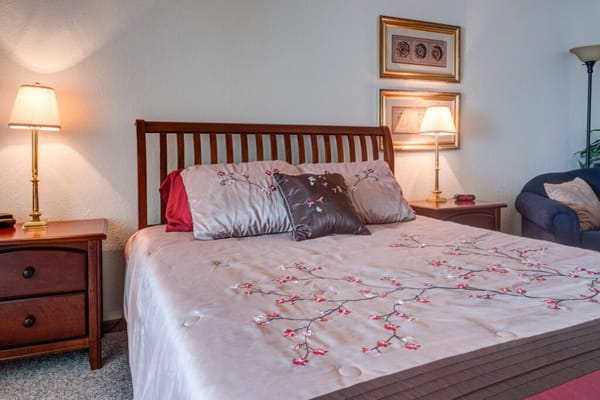 Cozy bedroom with floral bedding and lamps