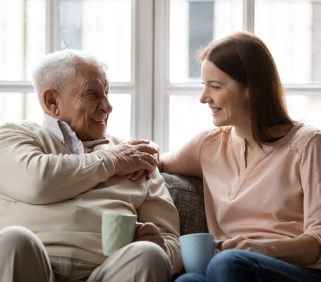 A resident and staff member sharing a moment over coffee