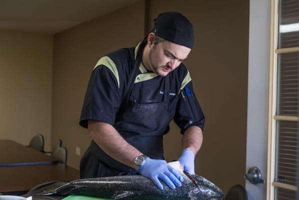 Chef preparing fish in an activity area
