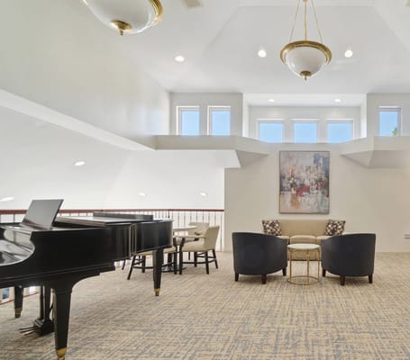 Bright common area featuring a piano and seating