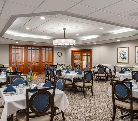 Dining room set up for a meal with tables and chairs