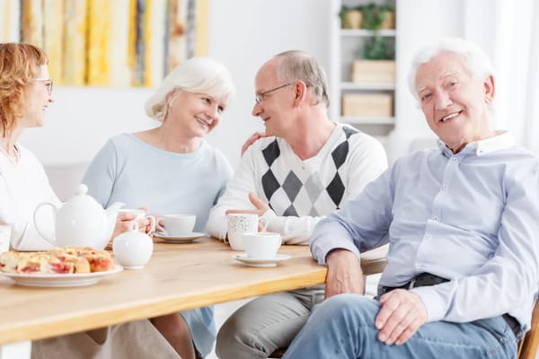 Residents enjoying coffee and conversation in a bright room