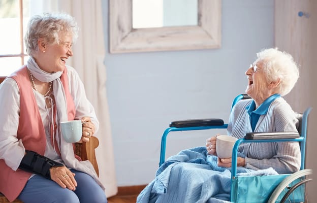 Two elderly women enjoying conversation in a cozy room