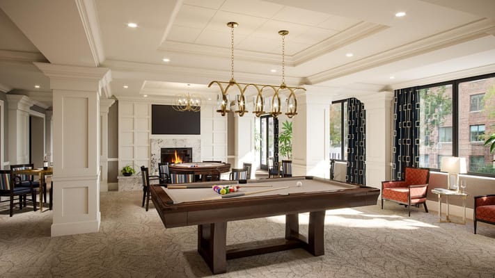 Well-lit common area with a pool table and seating