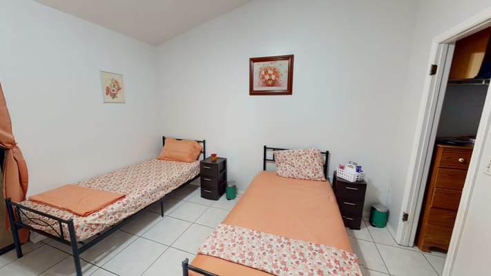 Two twin beds with floral bedding in a bright bedroom