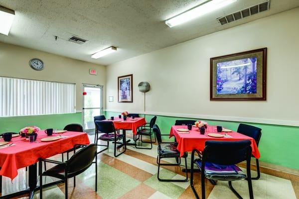 Dining area with red tablecloths and floral centerpieces