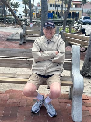 Elderly man seated outdoors in casual attire