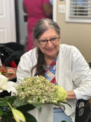 Resident smiling while holding a bouquet of flowers