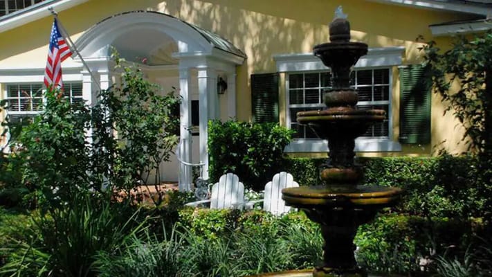 Exterior view of a residence with a fountain and garden