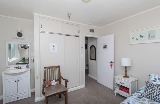 Private resident room with a cozy chair and lamp