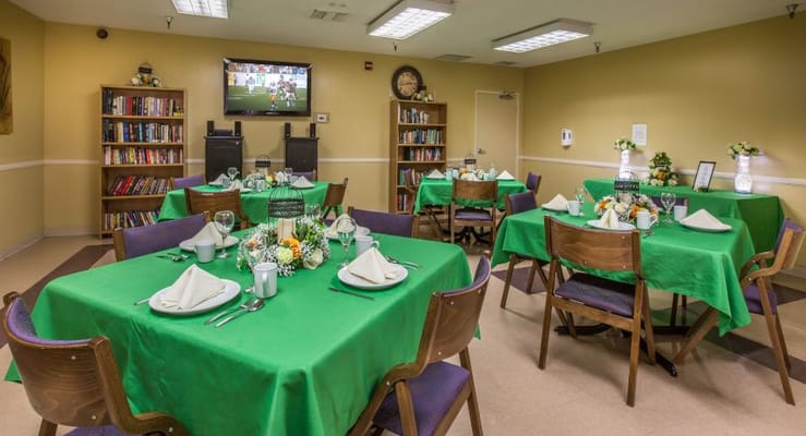 Dining area with green tables set for a meal