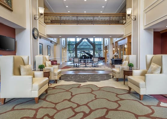 Bright lobby area with seating and a piano