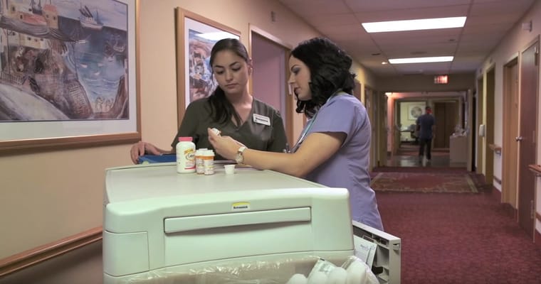 Staff members discussing medication in a hallway
