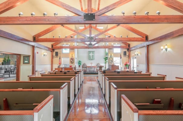 Interior view of a chapel with pews and wooden beams