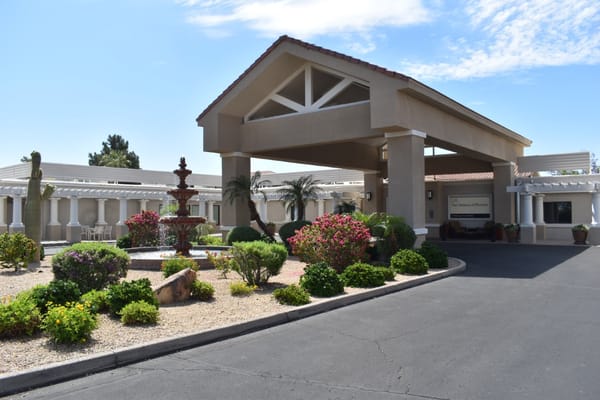 Welcoming entrance with a fountain and lush landscaping