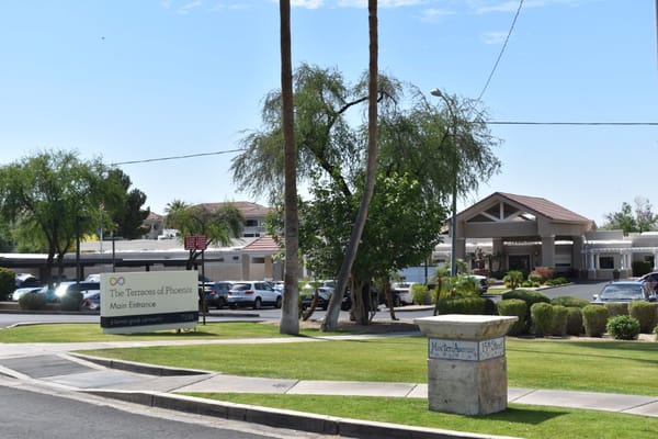 Main entrance sign of The Terraces of Phoenix with the building in the background