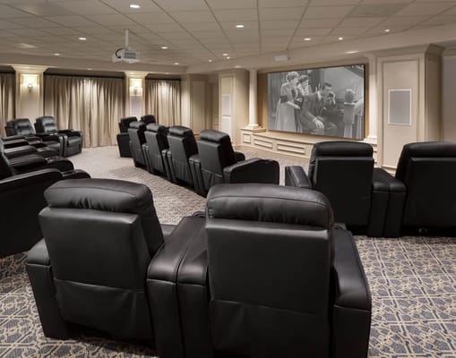 Theater room with reclining chairs and a large screen