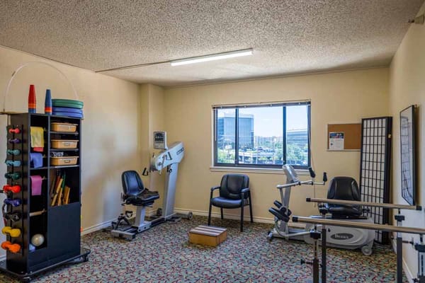 A fitness room with exercise equipment and seating area.