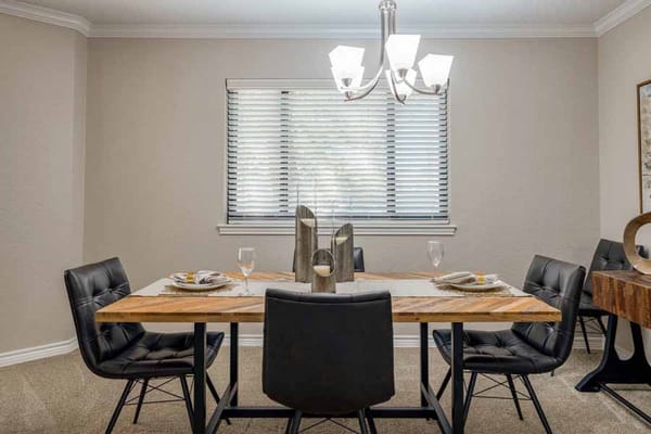 Modern dining area with a wooden table and black chairs