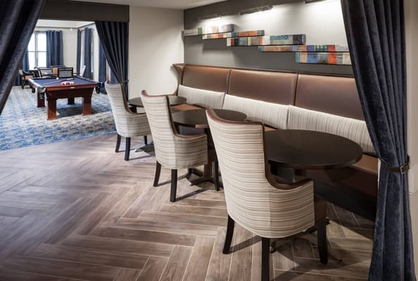 Cozy lounge area with seating and pool table in the background