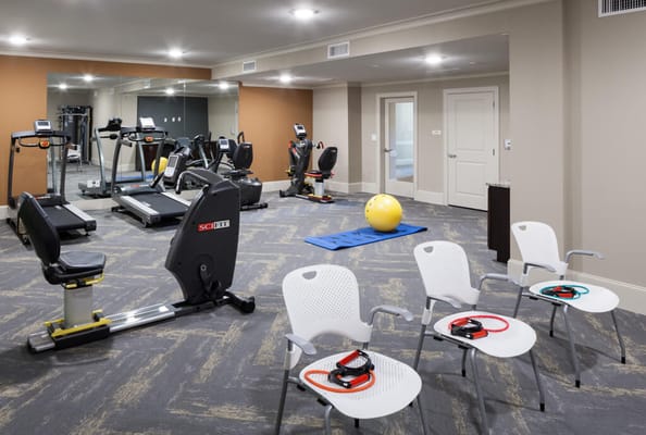 Fitness equipment in the gym with exercise mats and chairs