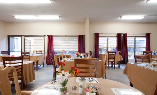 Bright dining area with tables and flowers