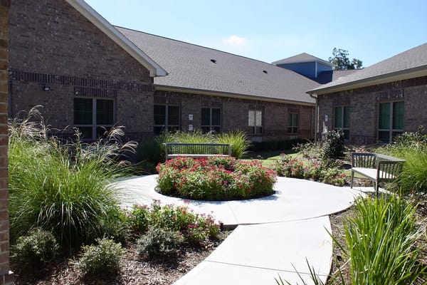 A landscaped courtyard featuring benches and flower beds.