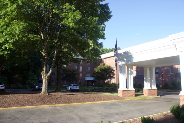 The entrance to The Barrington at Hioaks with trees and parked cars