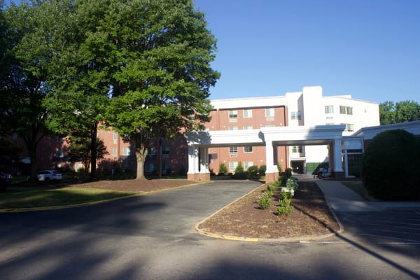 Entrance view of The Barrington at Hioaks with landscaping and a clear sky