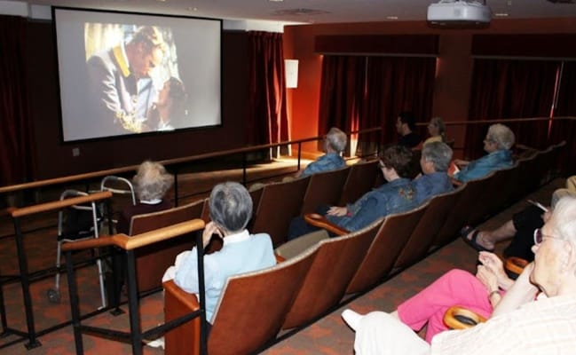 Residents enjoying a movie in the activity room