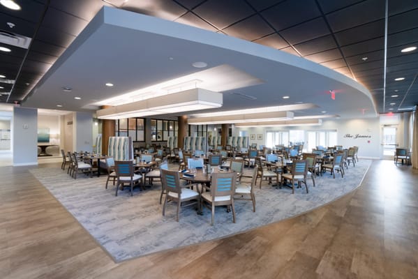 Bright dining room with tables and chairs set up