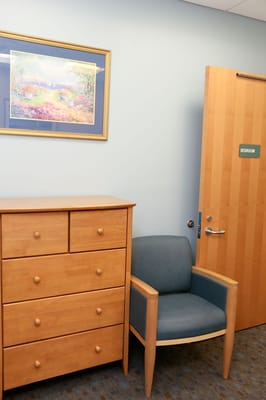 Interior view of a private resident room with a dresser and chair