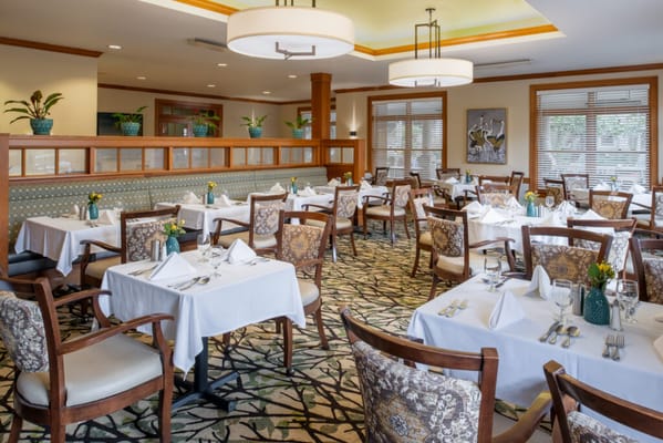 Elegant dining room with tables set for meals at NorthWest Place.