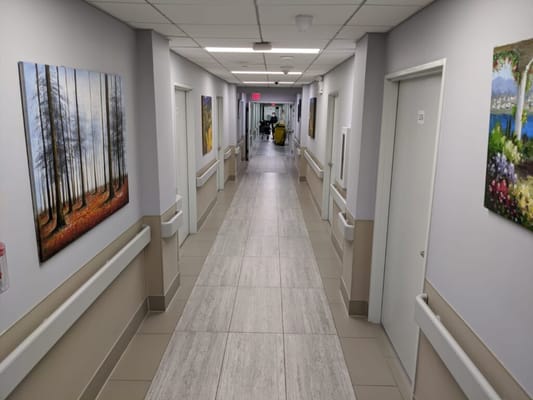 Bright hallway with artwork and cleaning staff