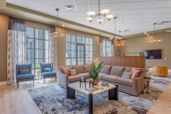 A modern lounge with comfortable seating and large windows.