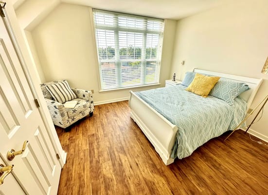 Bright and comfortable bedroom with a bed and a cozy chair.