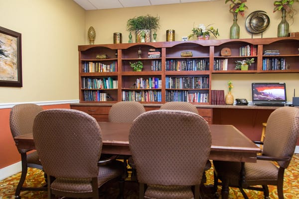 Conference room with a large wooden table and bookshelves filled with books