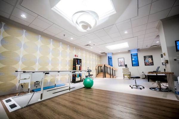 A therapy room featuring exercise equipment and a wooden staircase
