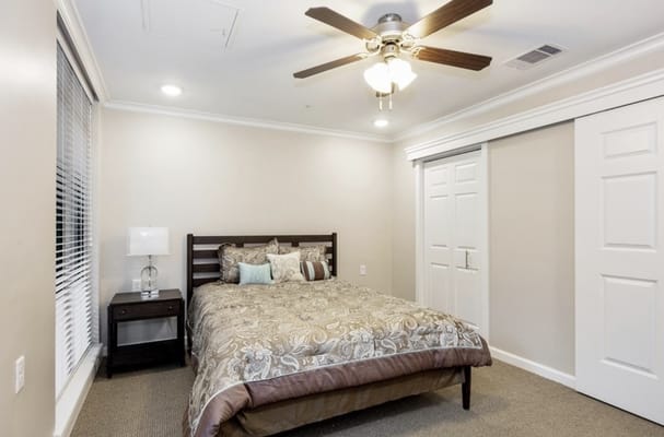 Spacious bedroom with a bed, bedside table, and closet