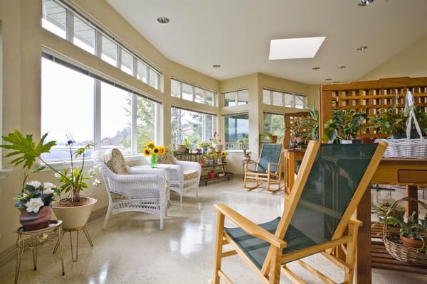 Sunroom with plants and comfortable seating at The Lakeshore