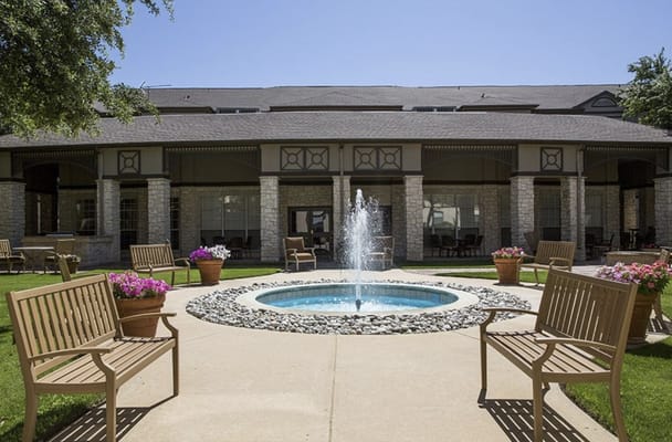 Outdoor seating area featuring a fountain and flower pots