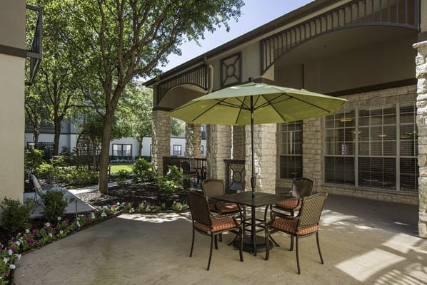 Cozy outdoor seating area with an umbrella and lush greenery
