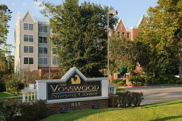 Entrance sign of The Vosswood Nursing Center with the building in the background.