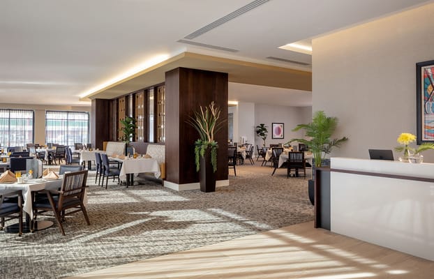 Bright and spacious dining area with tables set for meals.