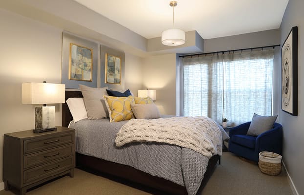 Bright and inviting bedroom with a bed, decorative pillows, and window.