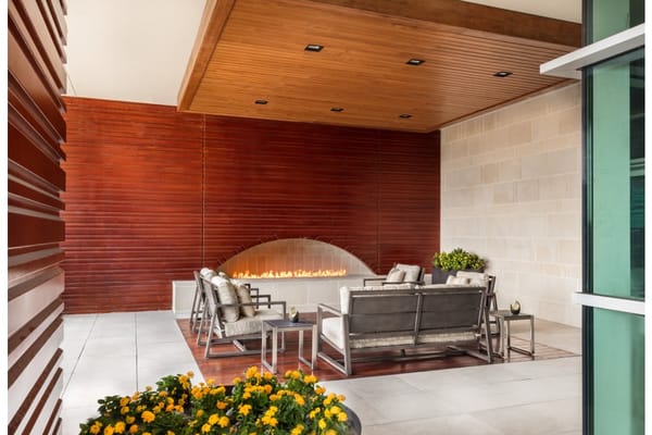 Cozy outdoor seating area with fireplace and flowers