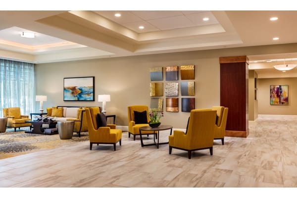 Bright, modern lobby with yellow chairs and artwork